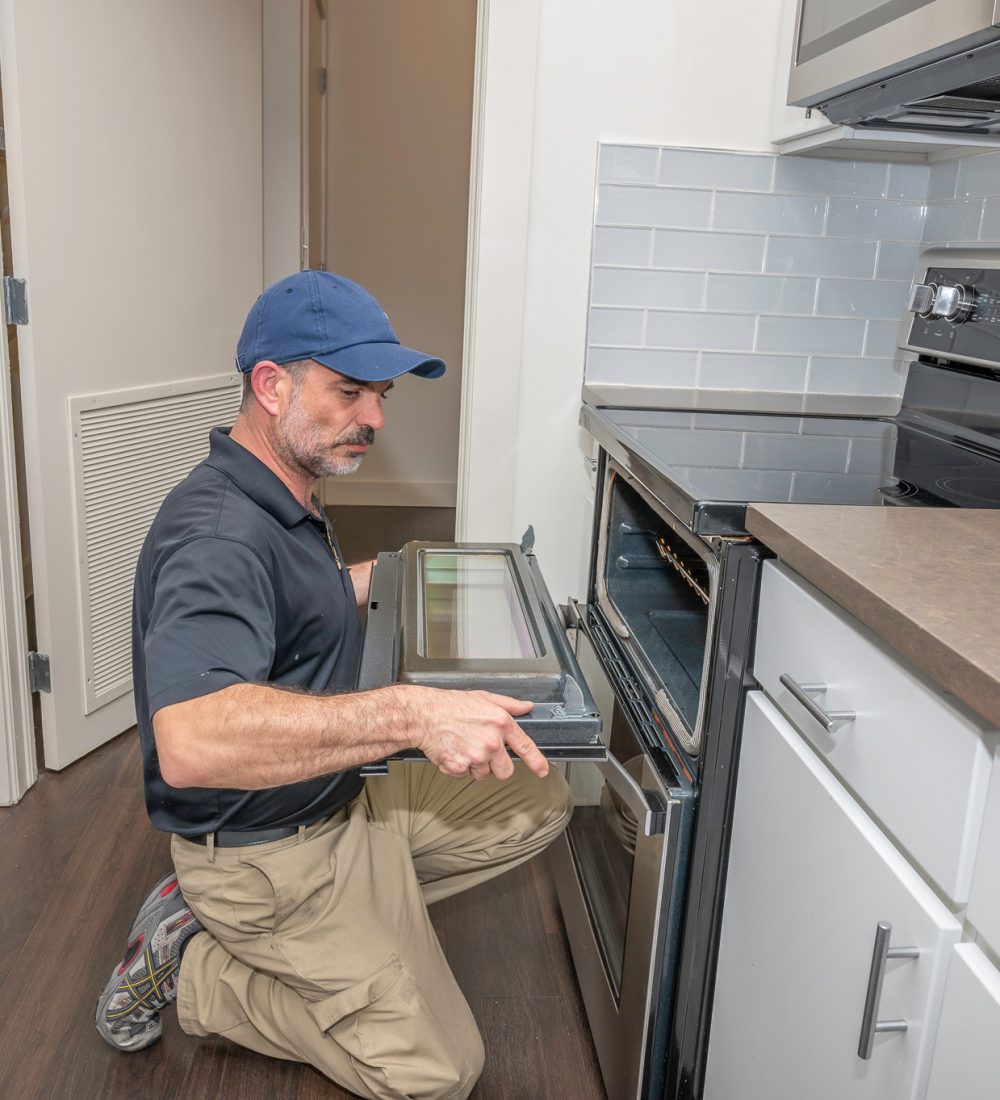 Appliance technician installing a oven door Appliance technician installing a oven door on a modern range